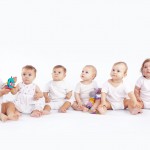 Group of babies sitting on white studio background